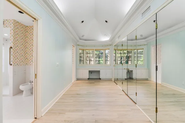 a view of a hallway with wooden floor and a bathroom