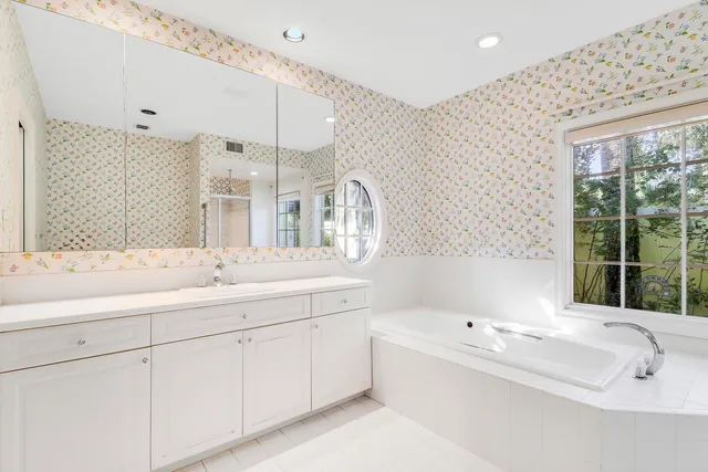a bathroom with a tub sink and mirror