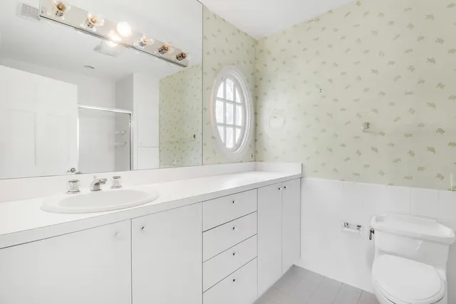 a spacious bathroom with a toilet sink and mirror