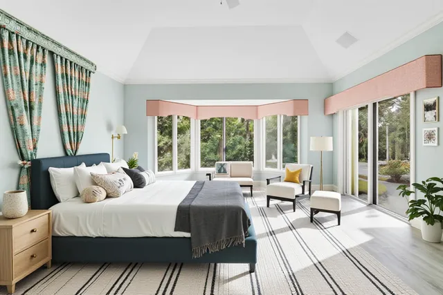 a bedroom with a bed and large windows