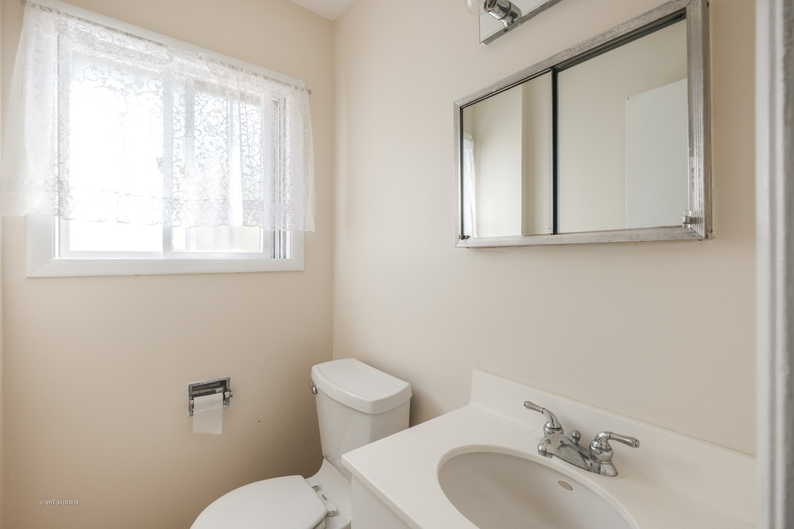 314 Skokie Road Wilmette, IL 60091 - Photo 9 of 14 a bathroom with a toilet sink a mirror and window