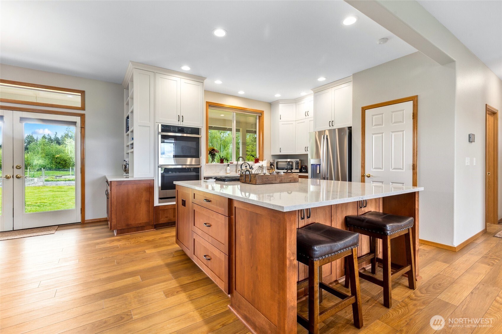 14419 Martinson Road Southeast Yelm, WA 98597 - Photo 10 of 39 a kitchen with kitchen island granite countertop wooden cabinets and dining table