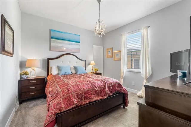 a bedroom with a bed and a flat tv screen on dresser