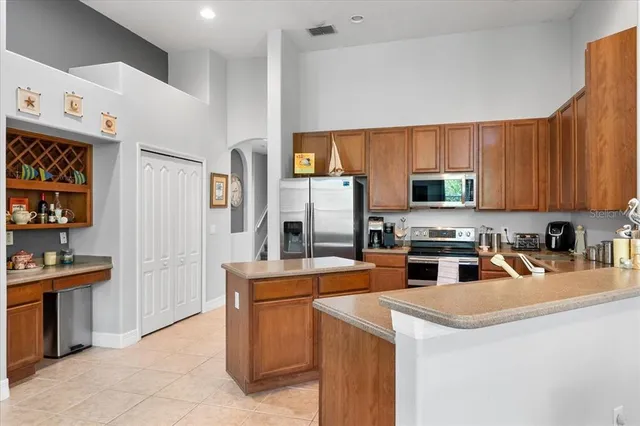 a kitchen with stainless steel appliances kitchen island granite countertop a refrigerator stove microwave and sink