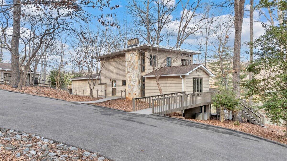 a view of a white house with a large tree