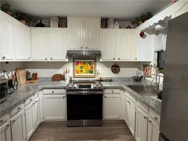 a kitchen with a sink stove top oven and cabinets