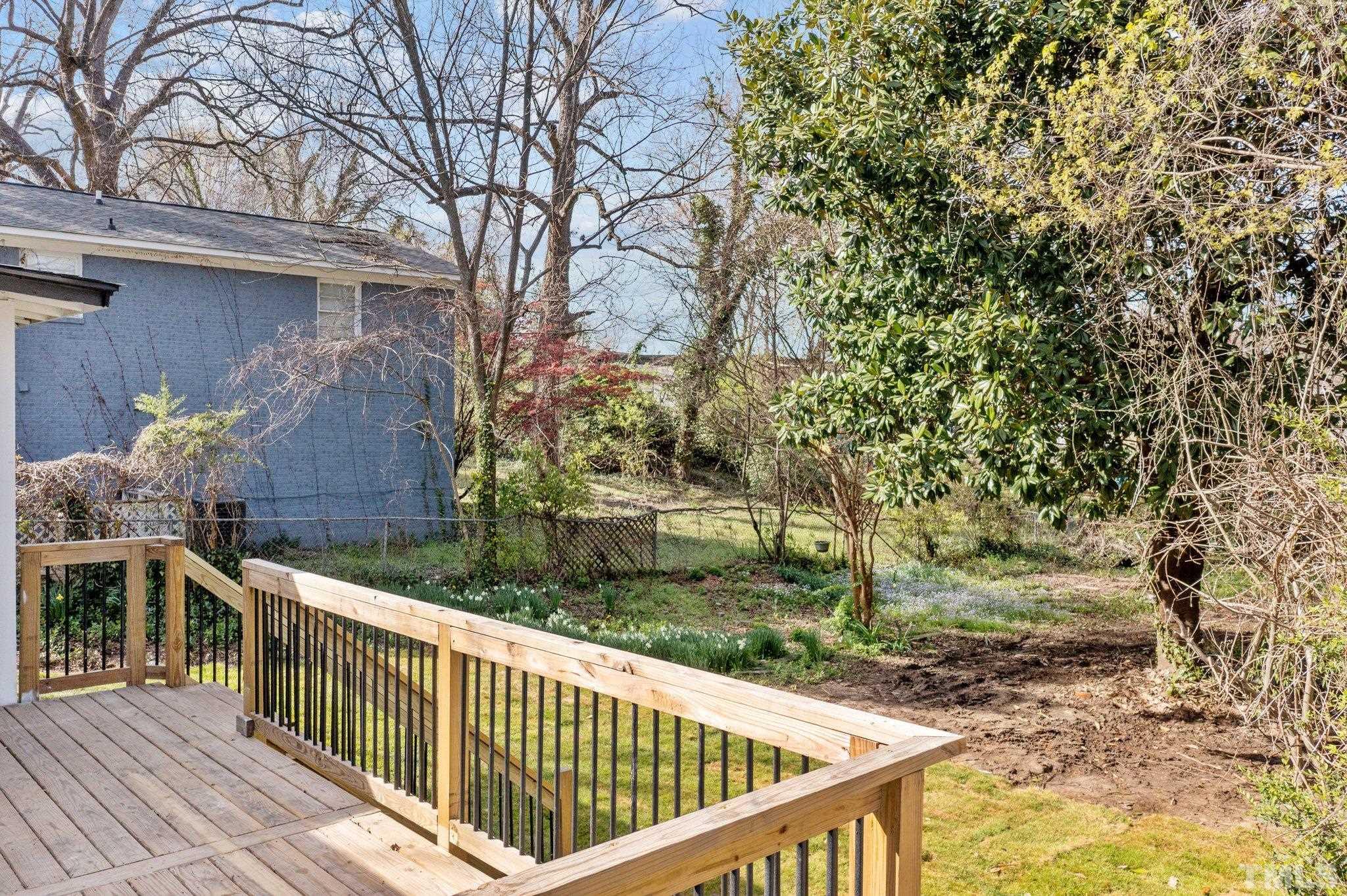 2908 Woods Place Raleigh, NC 27607 - Photo 14 of 38 a view of a wooden deck and a yard with wooden fence