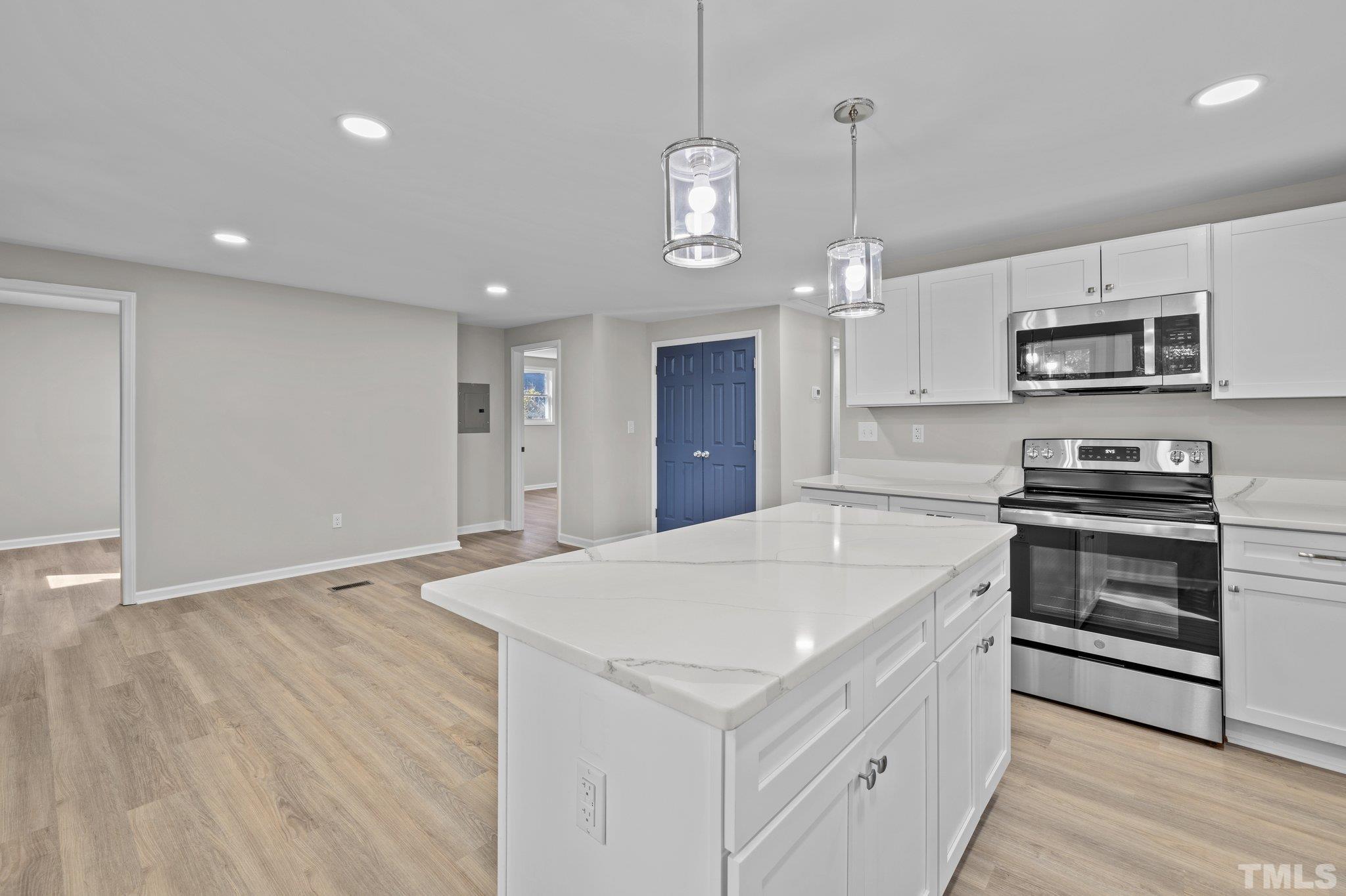 2908 Woods Place Raleigh, NC 27607 - Photo 27 of 38 a kitchen with stainless steel appliances a white stove top oven a sink dishwasher and a refrigerator with wooden floor