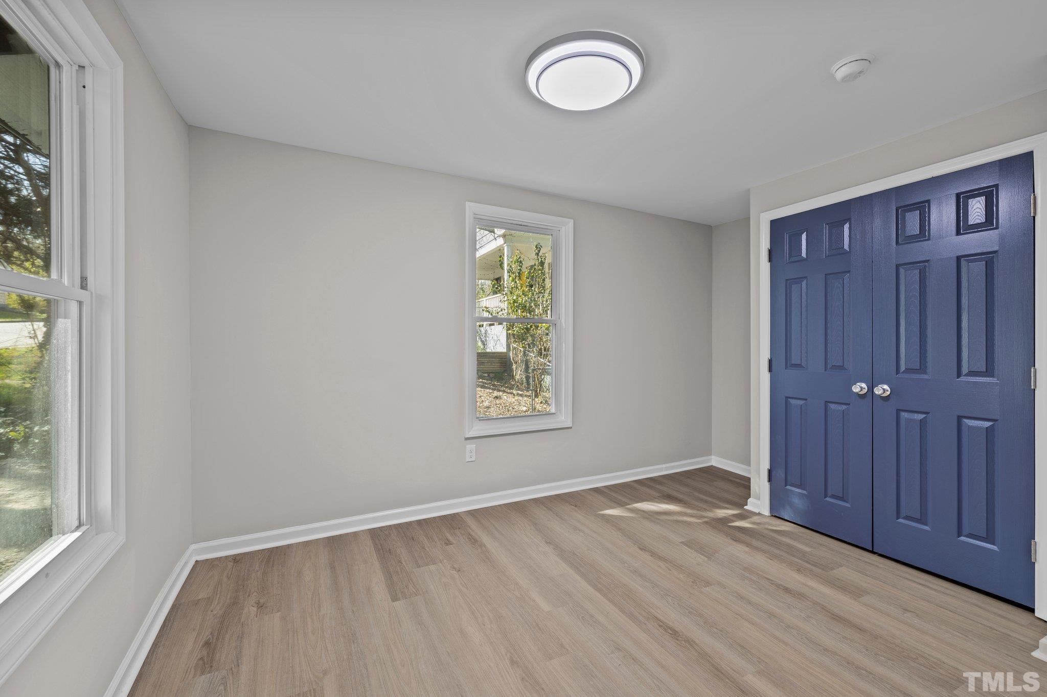 2908 Woods Place Raleigh, NC 27607 - Photo 28 of 38 an empty room with wooden floor and windows