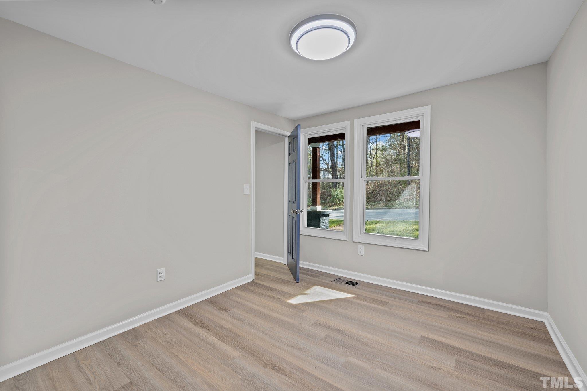 2908 Woods Place Raleigh, NC 27607 - Photo 29 of 38 an empty room with wooden floor and windows