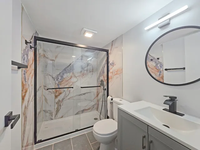 a bathroom with a sink mirror toilet and a shower