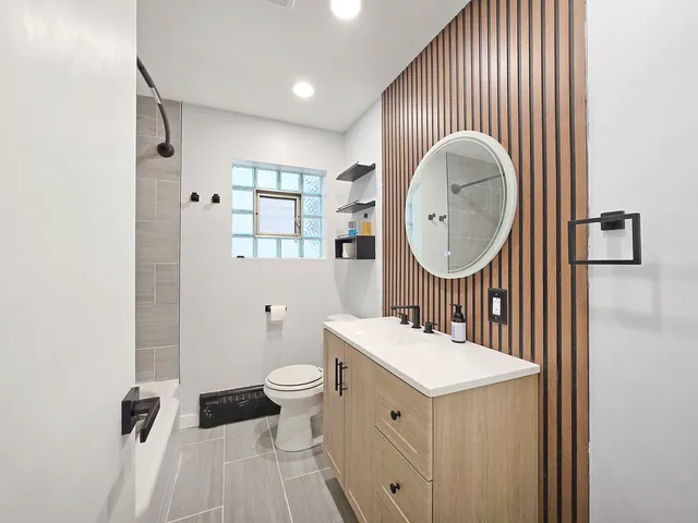 a bathroom with a sink mirror and toilet