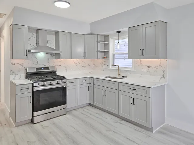 a kitchen with white cabinets stainless steel appliances and sink