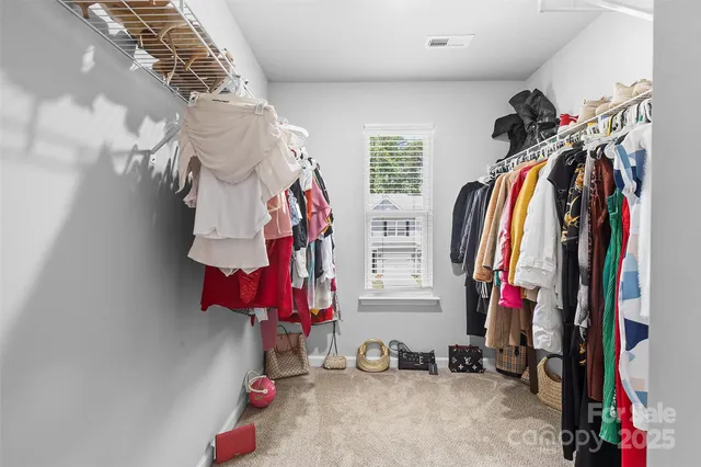 a view of walk in closet with clothes and shoes