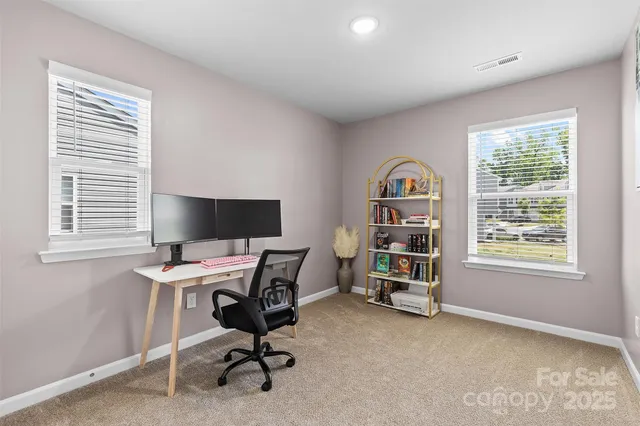 a view of a workspace with furniture and a window
