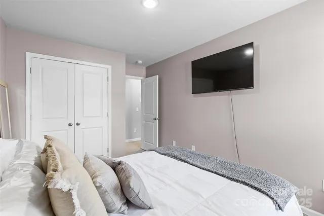 a bedroom with a large bed and a flat screen tv