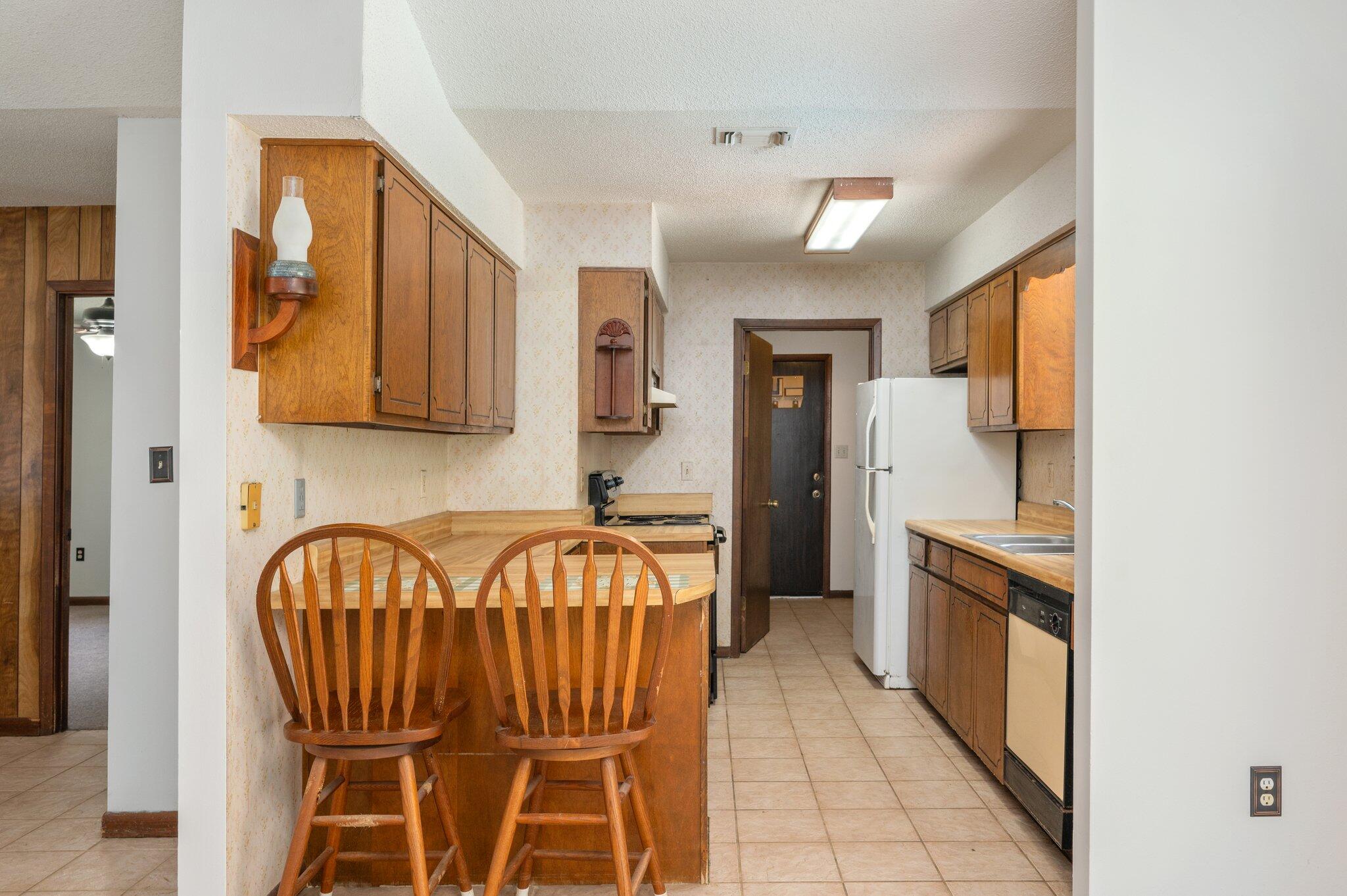 6141 Bud Moulton Road Crestview, FL 32536 - Photo 11 of 34 a kitchen with stainless steel appliances a refrigerator a stove a sink dishwasher with a dining table and chairs