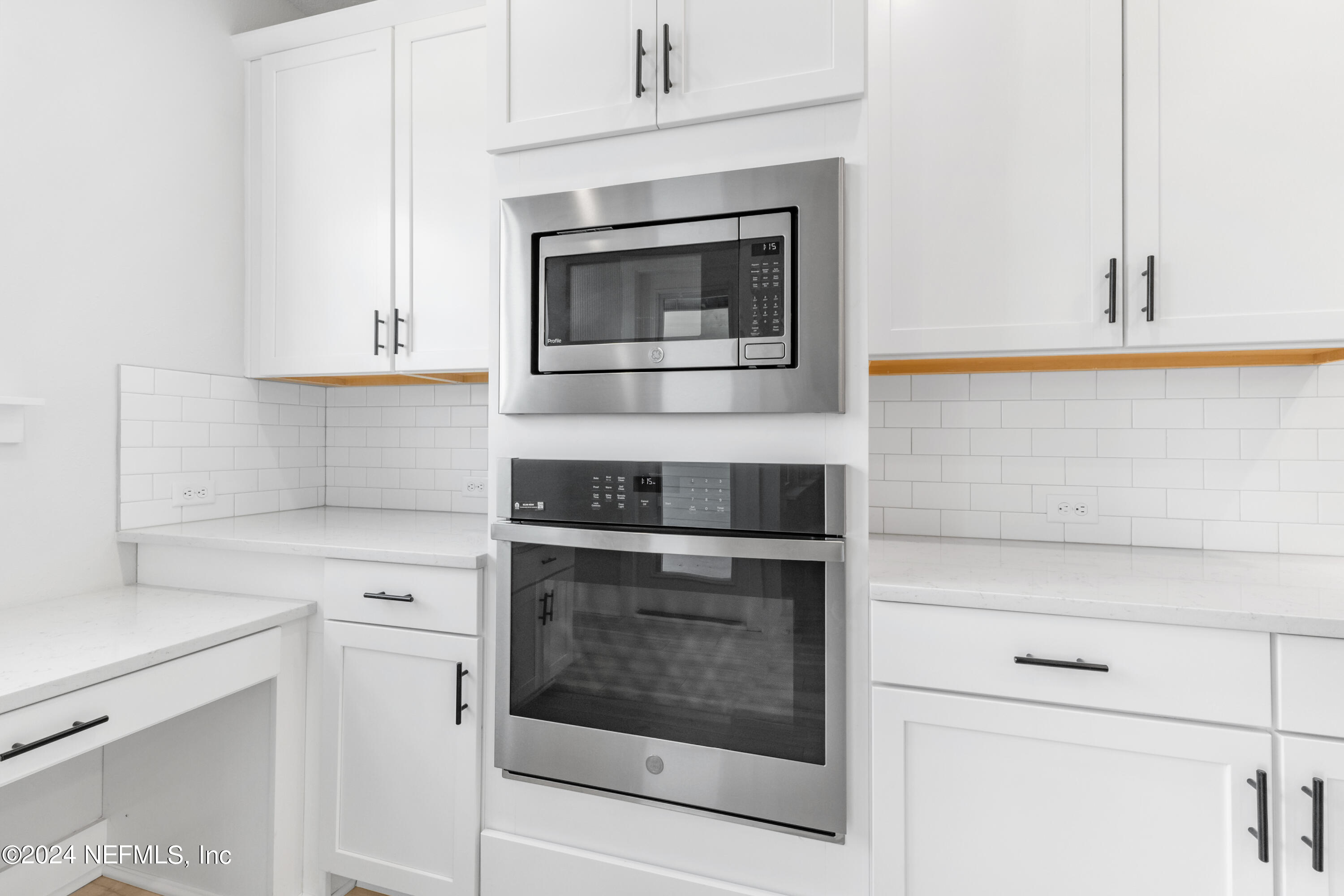 9828 Element Road Jacksonville, FL 32256 - Photo 6 of 17 a kitchen with white cabinets and stainless steel appliances