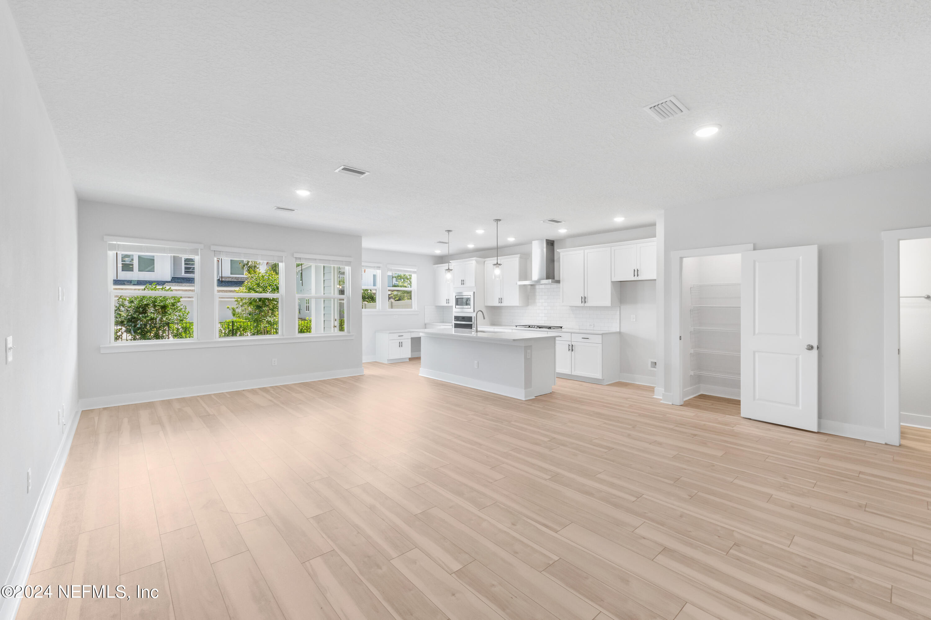 9828 Element Road Jacksonville, FL 32256 - Photo 10 of 17 a view of a kitchen with kitchen island and wooden floor