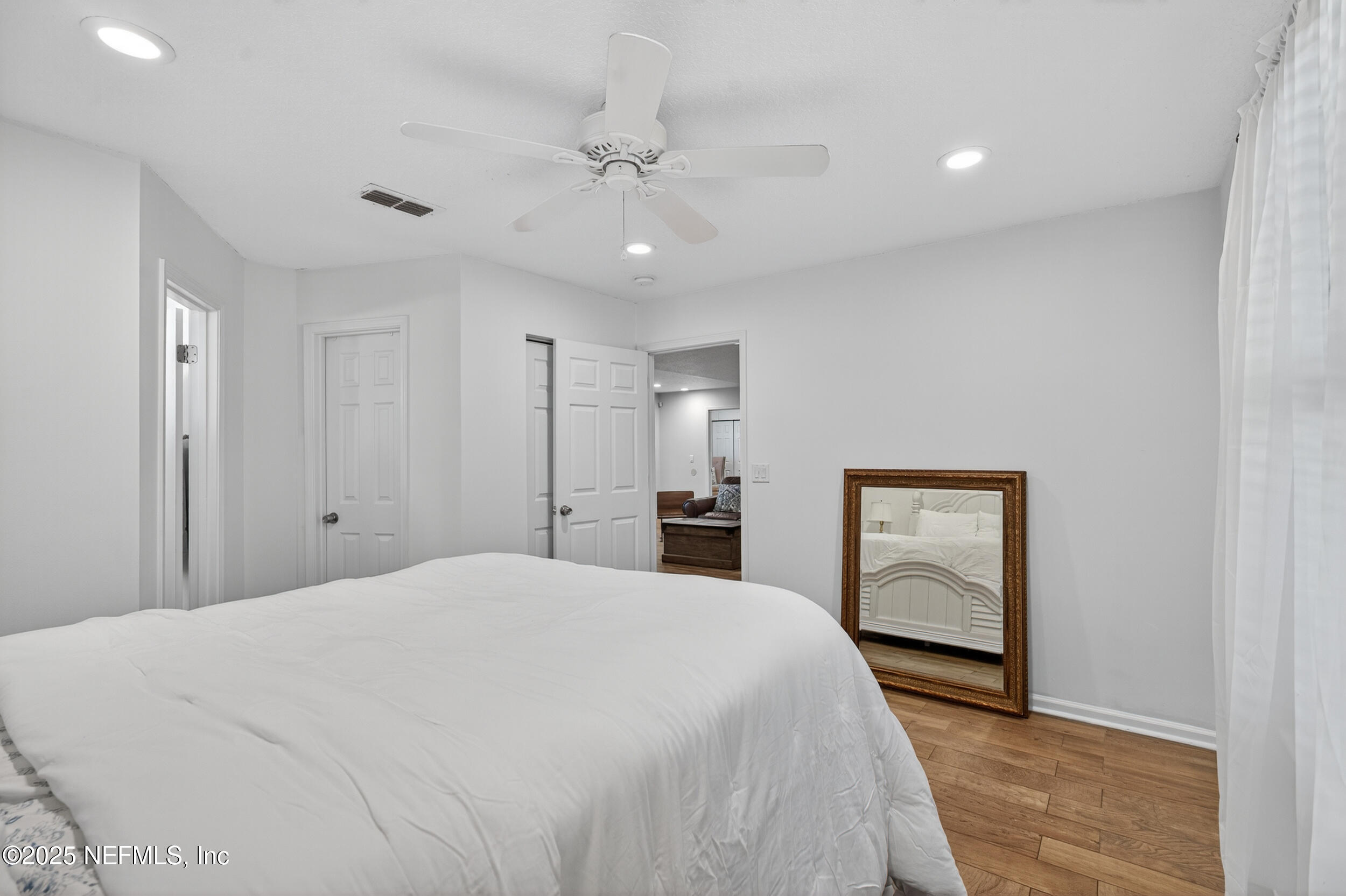 2836 Eagle Point Road Middleburg, FL 32068 - Photo 27 of 44 a spacious bedroom with a large bed and a chandelier