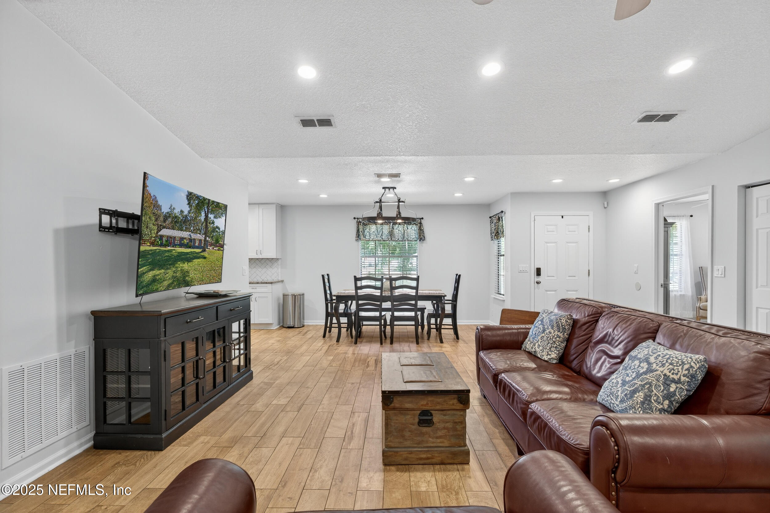 2836 Eagle Point Road Middleburg, FL 32068 - Photo 8 of 44 a living room with furniture a flat screen tv and kitchen view