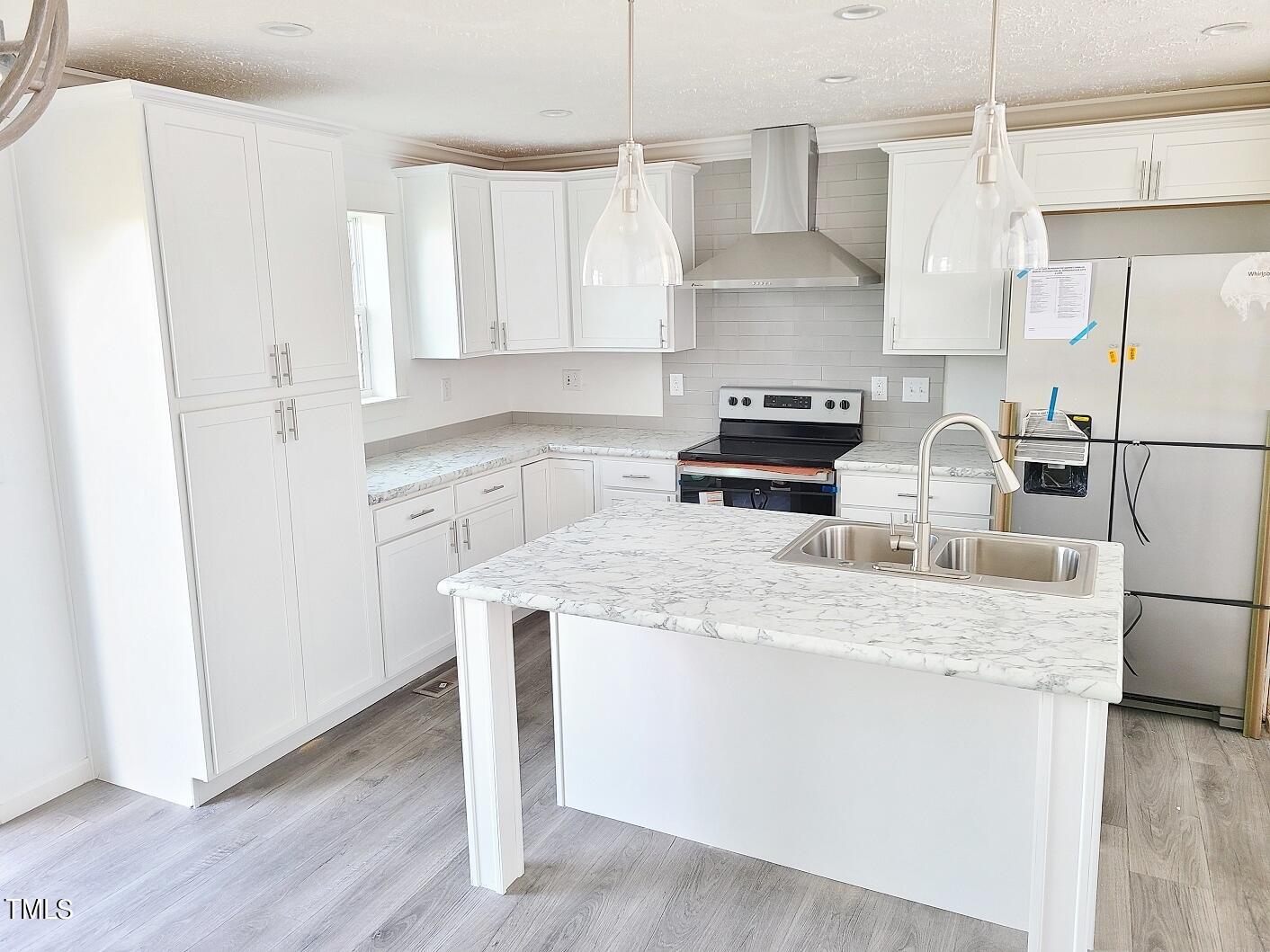 1398 Earpsboro Road Zebulon, NC 27597 - Photo 4 of 14 a kitchen with stainless steel appliances granite countertop a sink stove a refrigerator and white cabinets with wooden floor