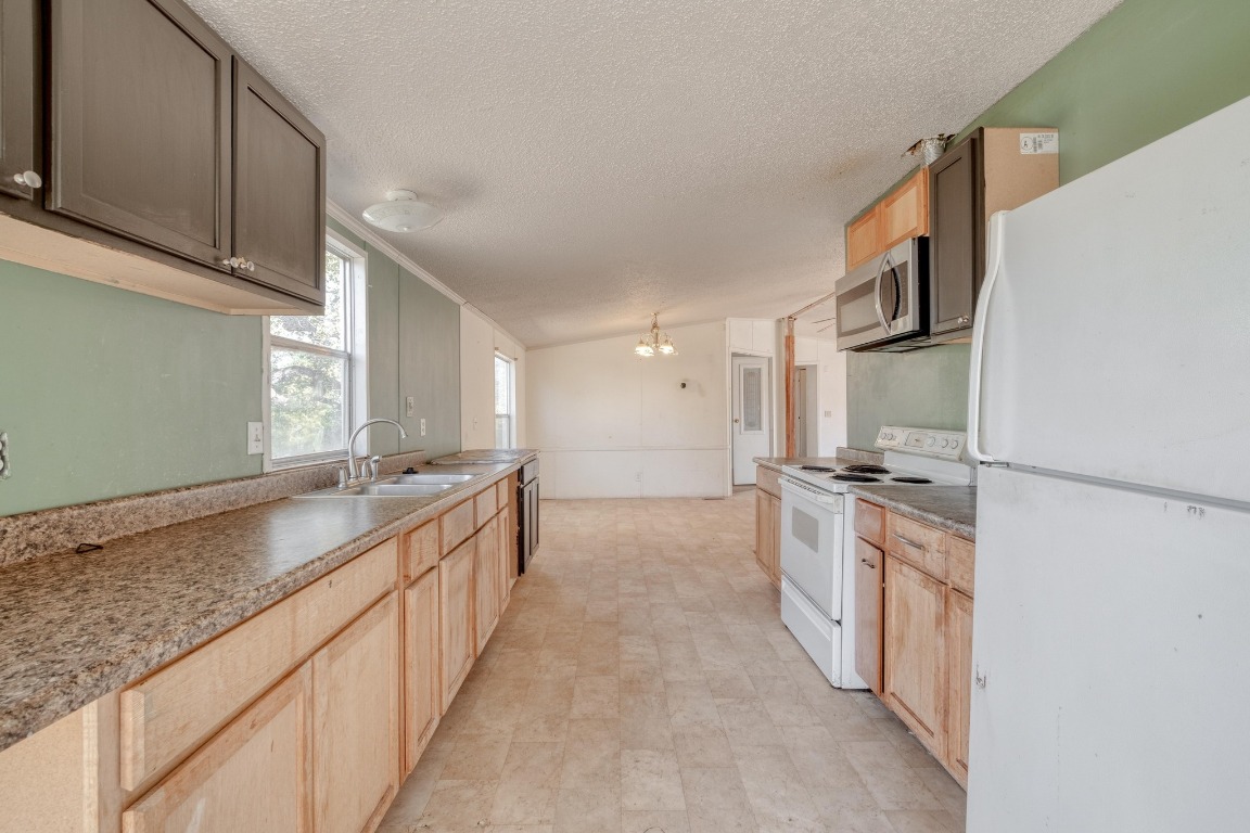 21400 Webberwood Ridge Drive Elgin, TX 78621 - Photo 7 of 22 a large kitchen with stainless steel appliances granite countertop a lot of counter space and a sink
