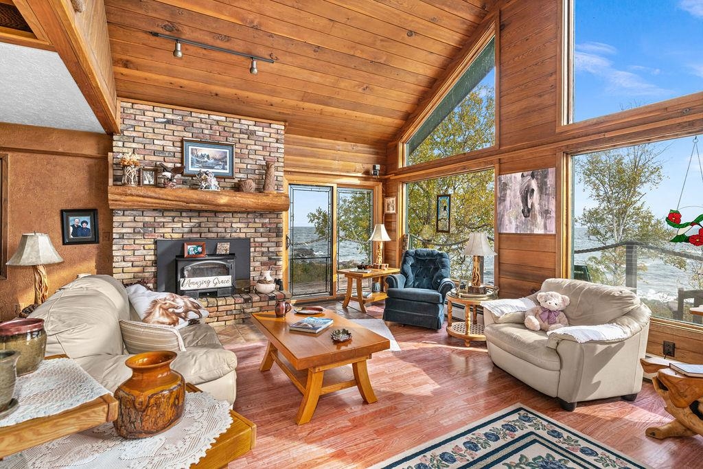 4346 Highway 61 Two Harbors, MN 55616 - Photo 37 of 65 Living room with wooden walls, high vaulted ceiling, wood ceiling, wood finished floors, and a fireplace