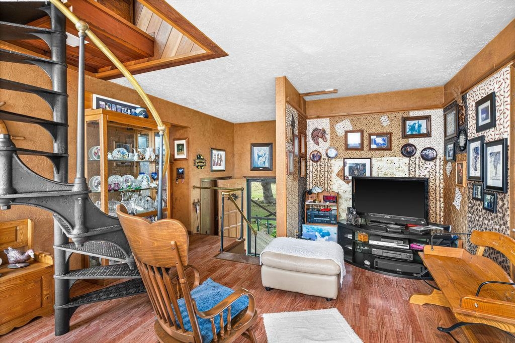 4346 Highway 61 Two Harbors, MN 55616 - Photo 40 of 65 Living room with wood finished floors, a textured ceiling, and a wood stove