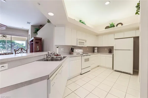 a kitchen with white cabinets and white appliances