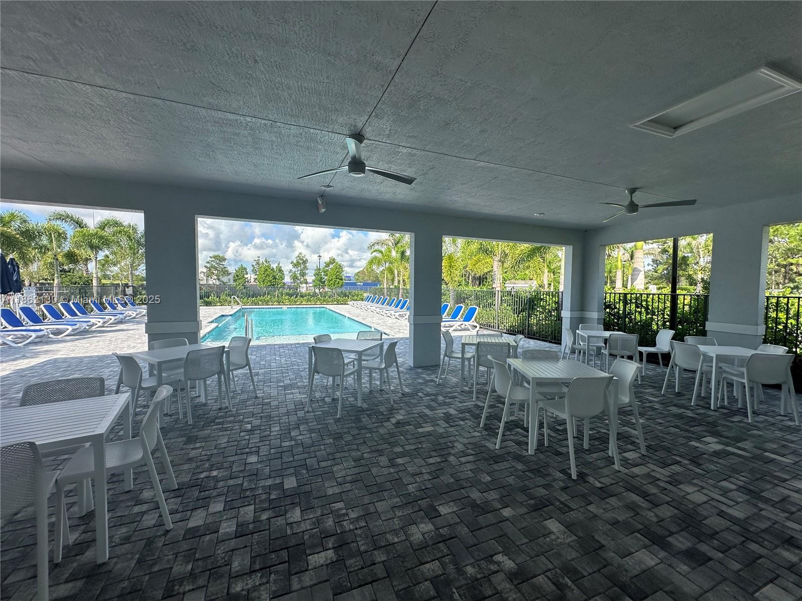 402 Southeast Crossoak Lane, Unit 402 Port St. Lucie, FL 34984 - Photo 11 of 87 a dining room with furniture a chandelier and pool table