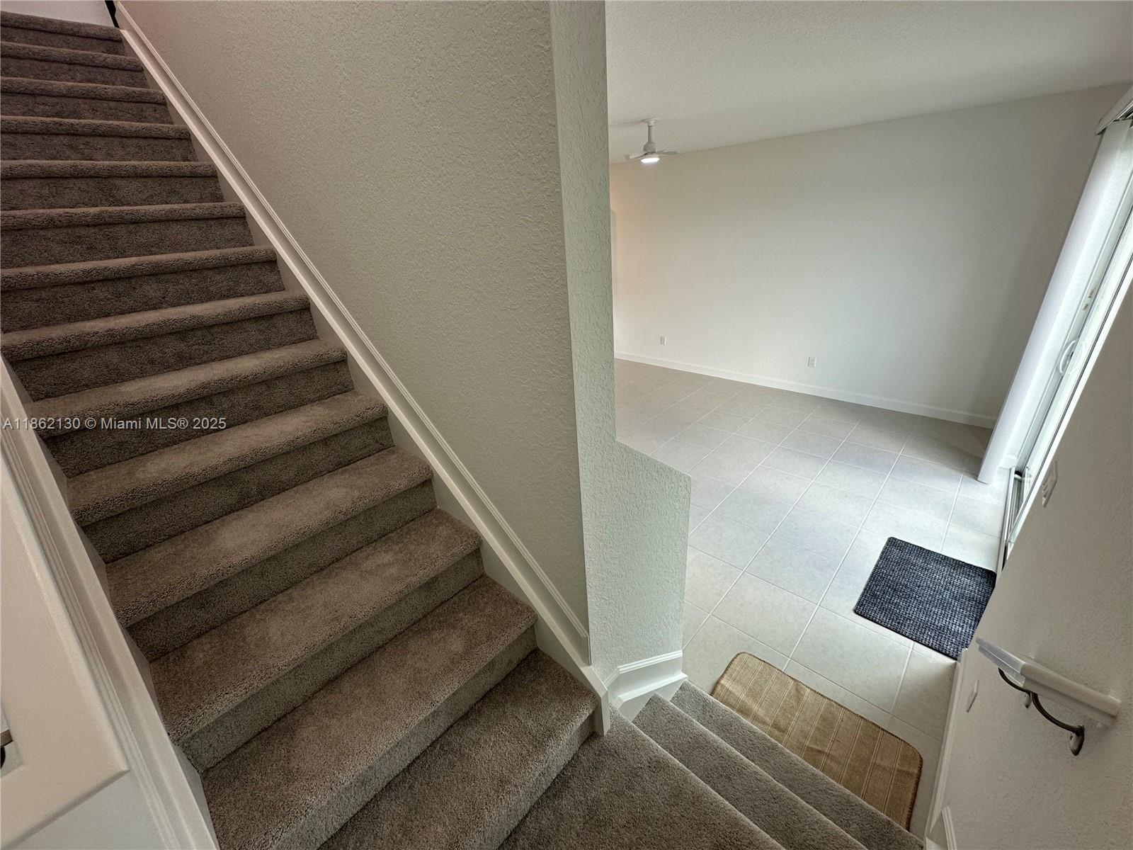 402 Southeast Crossoak Lane, Unit 402 Port St. Lucie, FL 34984 - Photo 30 of 87 a view of staircase with white walls and a window