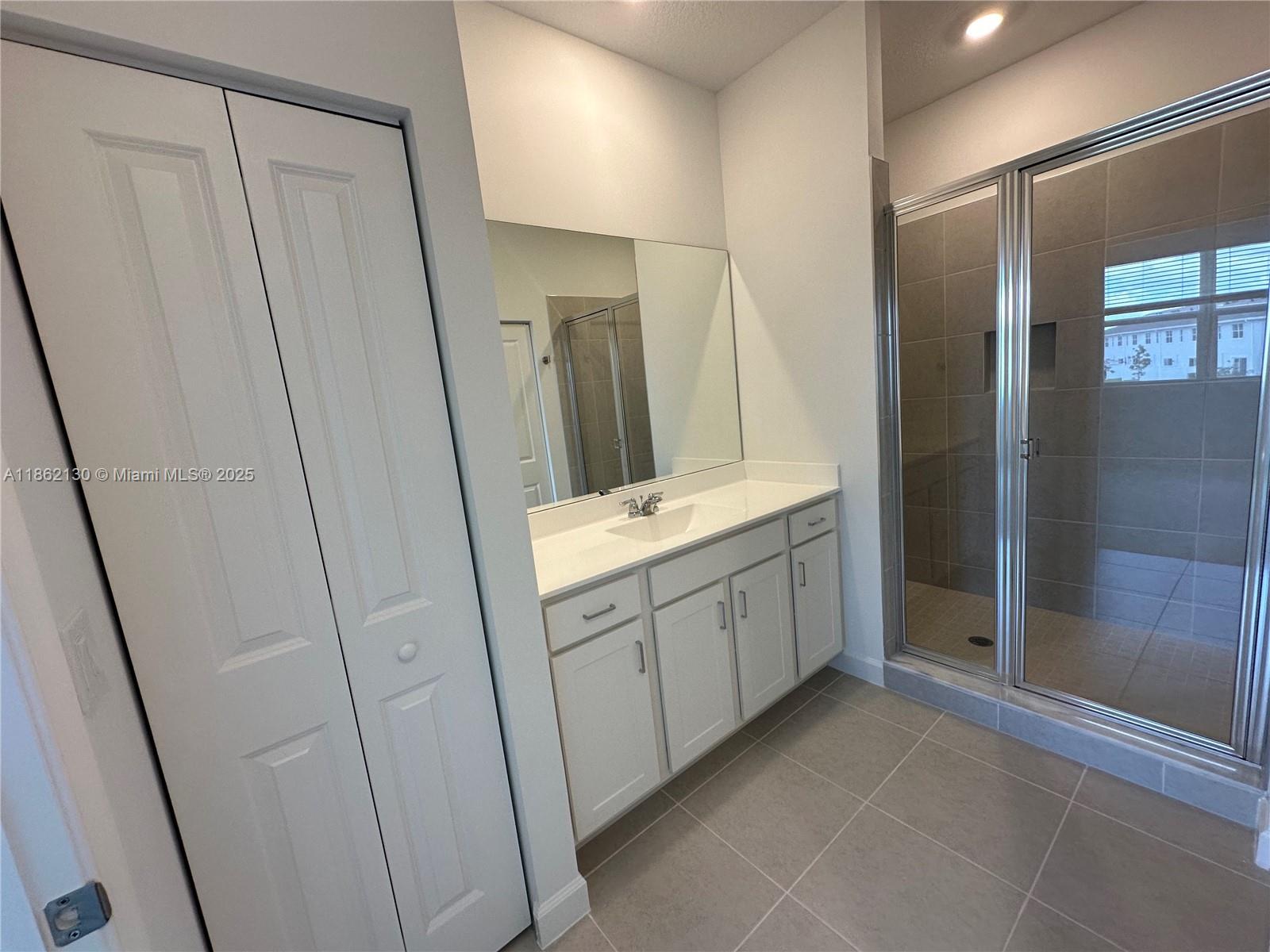 402 Southeast Crossoak Lane, Unit 402 Port St. Lucie, FL 34984 - Photo 37 of 87 a bathroom with a double vanity sink and a mirror