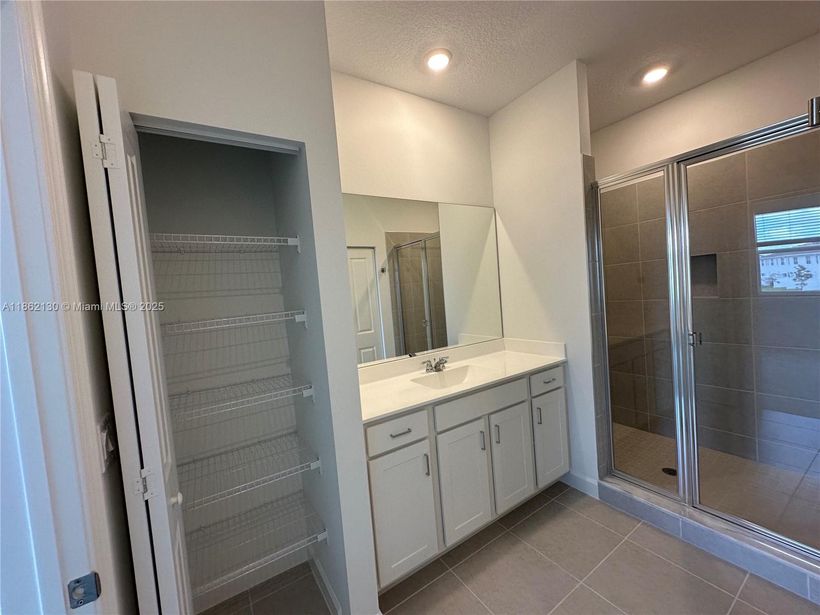 402 Southeast Crossoak Lane, Unit 402 Port St. Lucie, FL 34984 - Photo 38 of 87 a bathroom with a double vanity sink and a mirror