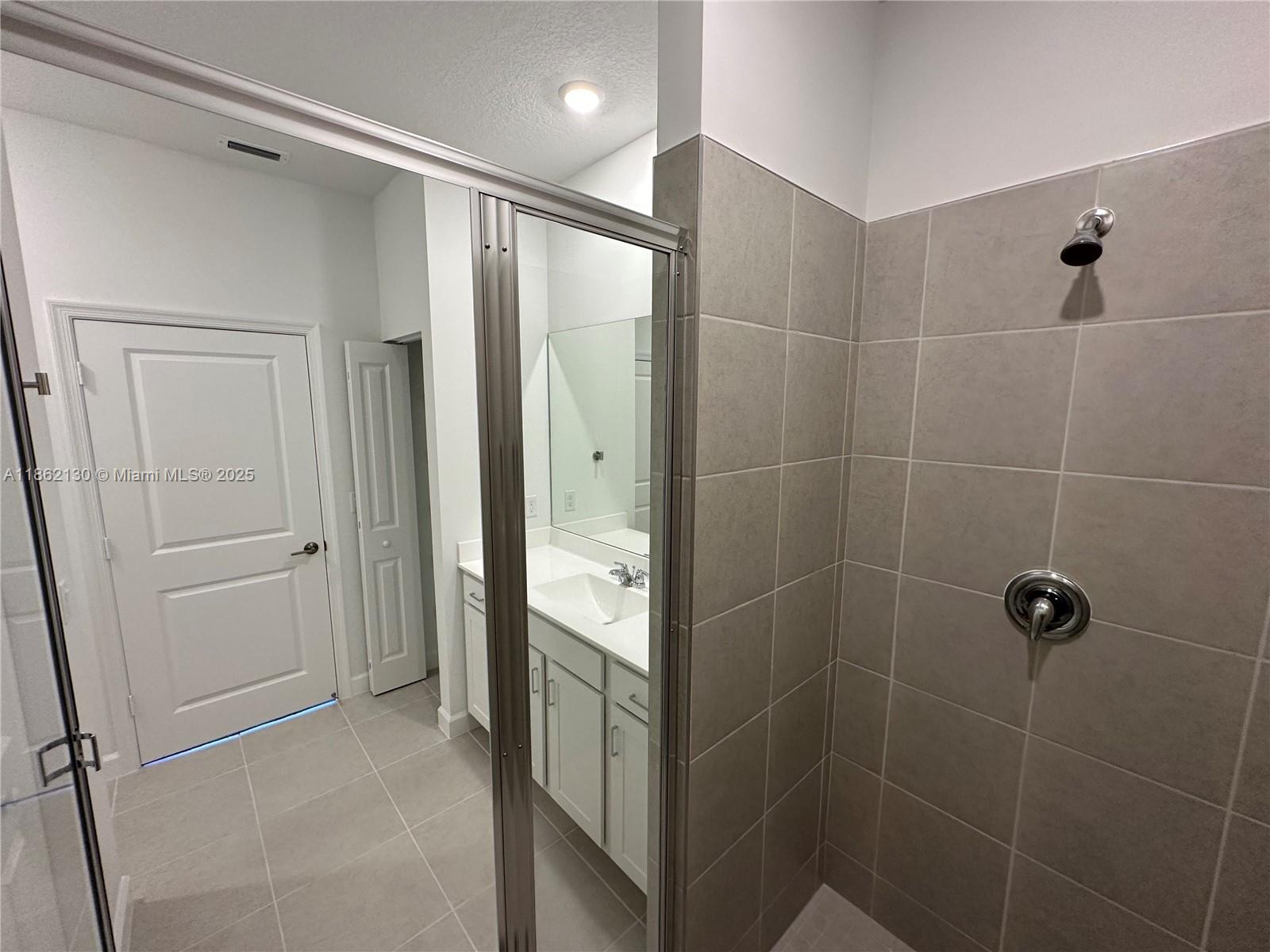 402 Southeast Crossoak Lane, Unit 402 Port St. Lucie, FL 34984 - Photo 45 of 87 a bathroom with a shower and a glass door