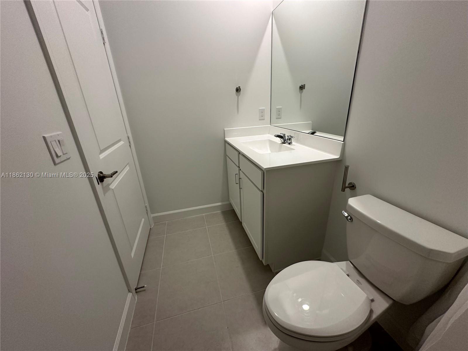 402 Southeast Crossoak Lane, Unit 402 Port St. Lucie, FL 34984 - Photo 58 of 87 a white toilet sitting next to a bathroom sink