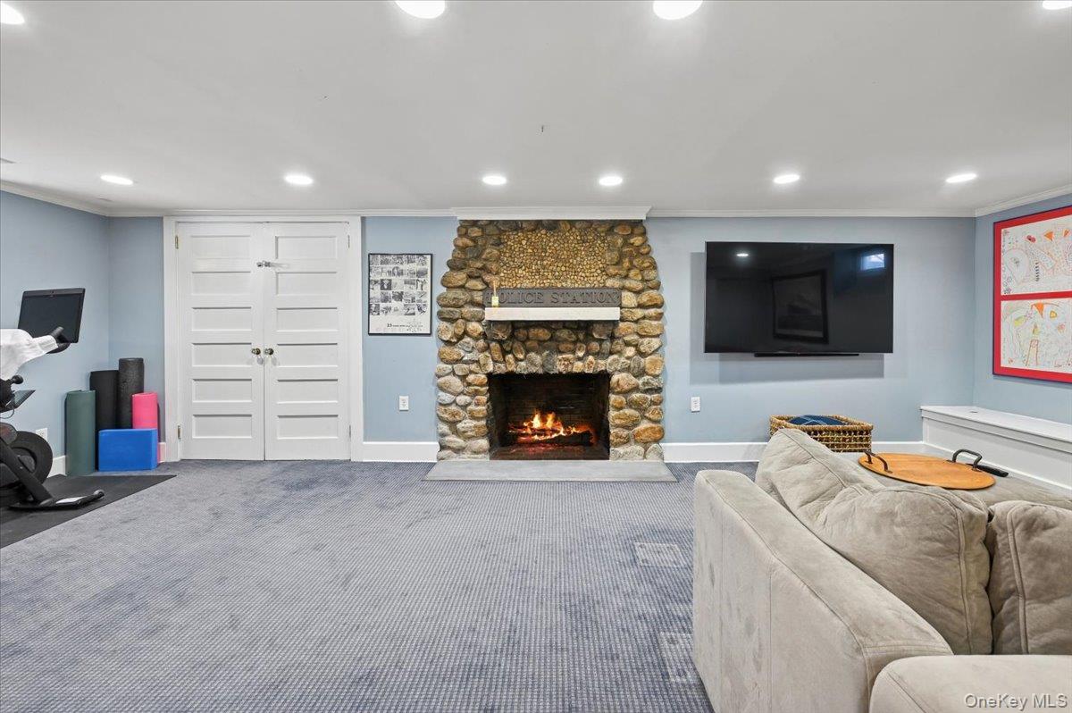 31 Emerson Road Larchmont, NY 10538 - Photo 33 of 43 The basement has a large stone fireplace that has been restored. The double white doors to the left lead into a very large storage space with floor to ceiling shelving.