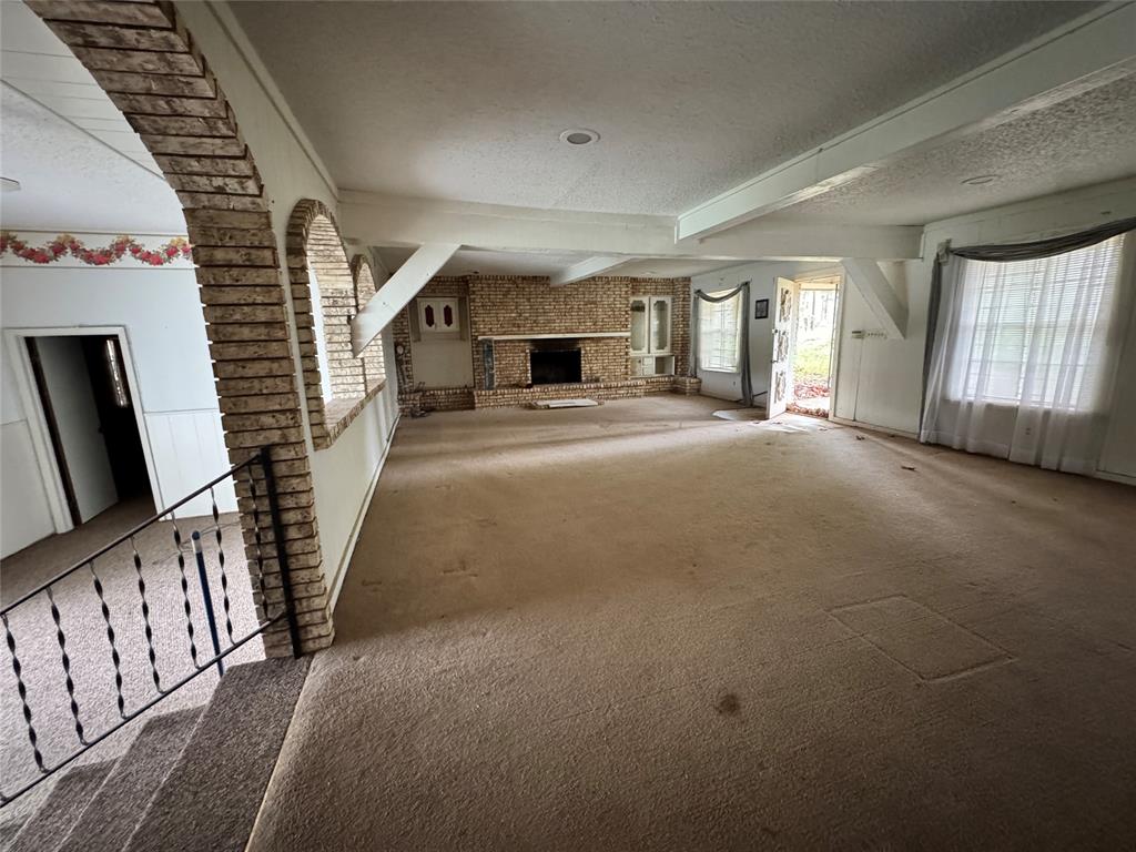 3909 Smothers Road Caney City, TX 75148 - Photo 11 of 35 en empty room with windows and fireplace