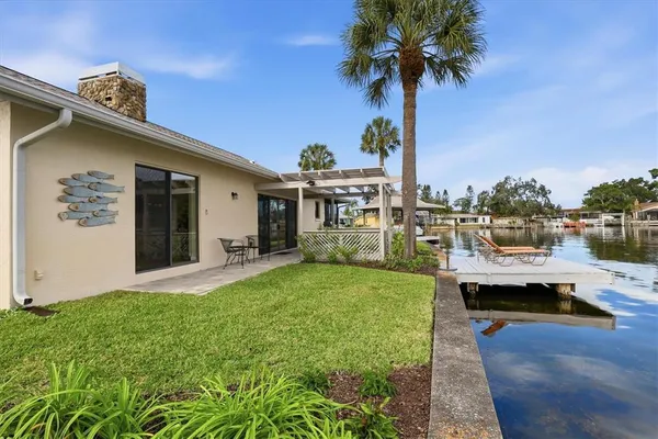 a view of a house with pool and chairs