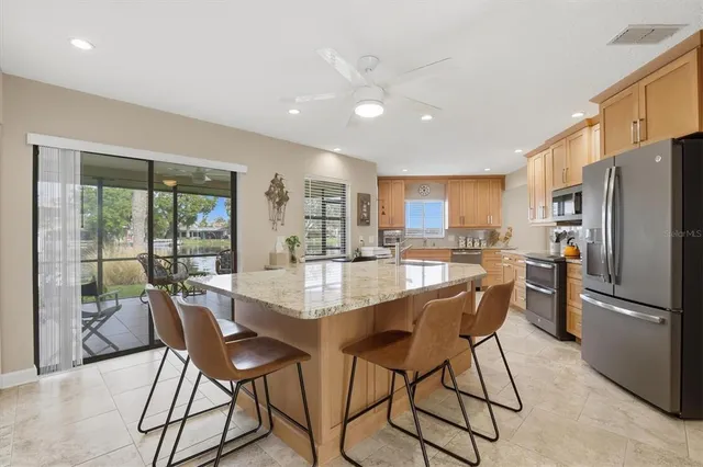 a kitchen with kitchen island a sink stove and refrigerator