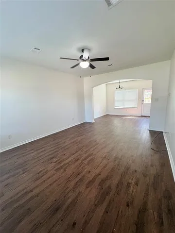 a view of a room with wooden floor and a ceiling fan