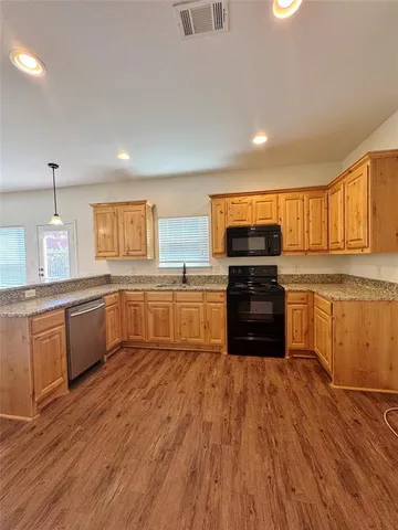 a kitchen with granite countertop a stove top oven sink and cabinets