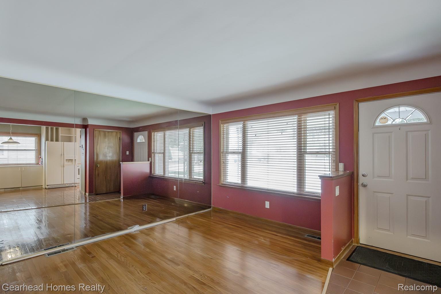 3356 Harding Street Dearborn, MI 48124 - Photo 5 of 48 Hardwood flooring, mirrored wall, multiple windows with blinds, white paneled door with decorative glass, and a tiled entryway