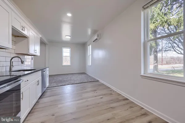 en empty room with windows and brick walls