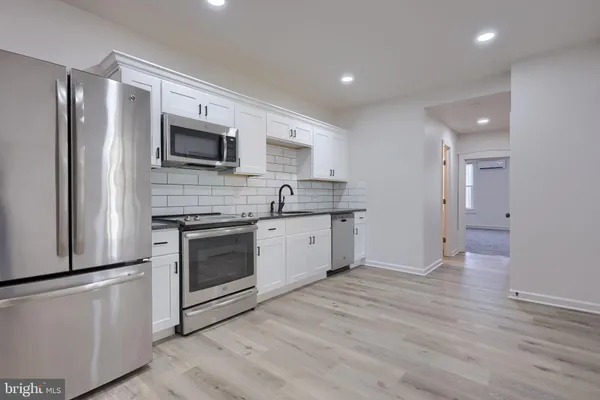 a kitchen with stainless steel appliances a refrigerator sink and microwave