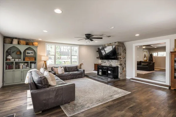 a living room with furniture large window and a fireplace