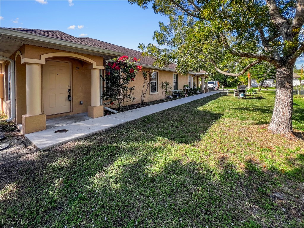 13437 First Street Fort Myers, FL 33905 - Photo 1 of 22 a front view of a house with a yard and porch