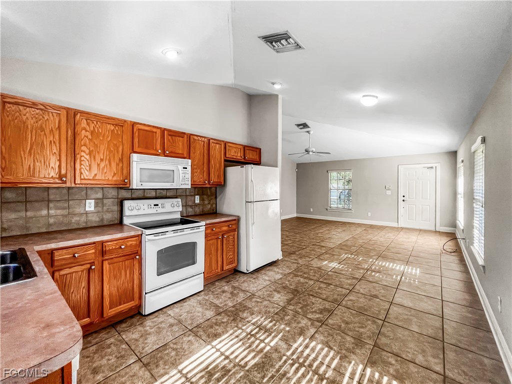 13437 First Street Fort Myers, FL 33905 - Photo 10 of 22 a kitchen with stainless steel appliances granite countertop a refrigerator and a stove top oven