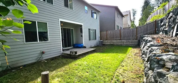 a view of a house with backyard and sitting area