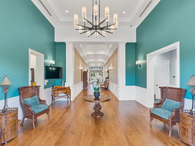 a dining room with wooden floor a chandelier a wooden table and chairs